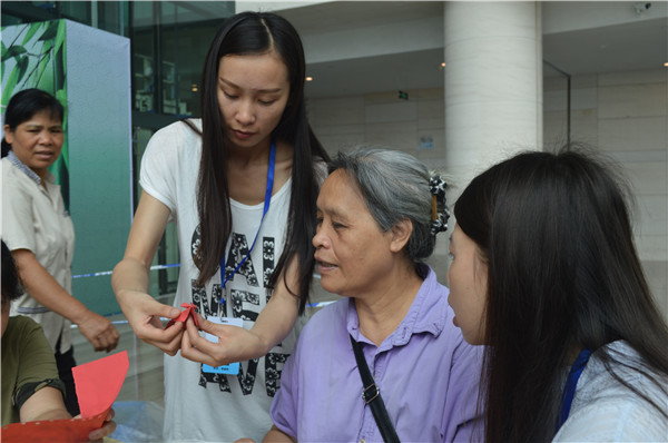 1465460400895960.jpg 折“龙舟”过端午工作人员耐心教观众折“龙舟”.jpg